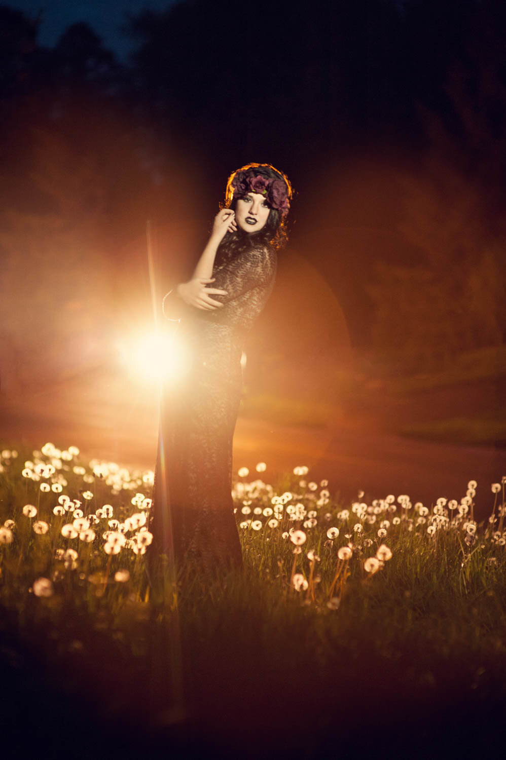 high school senior photo of girl in dandelion field at night