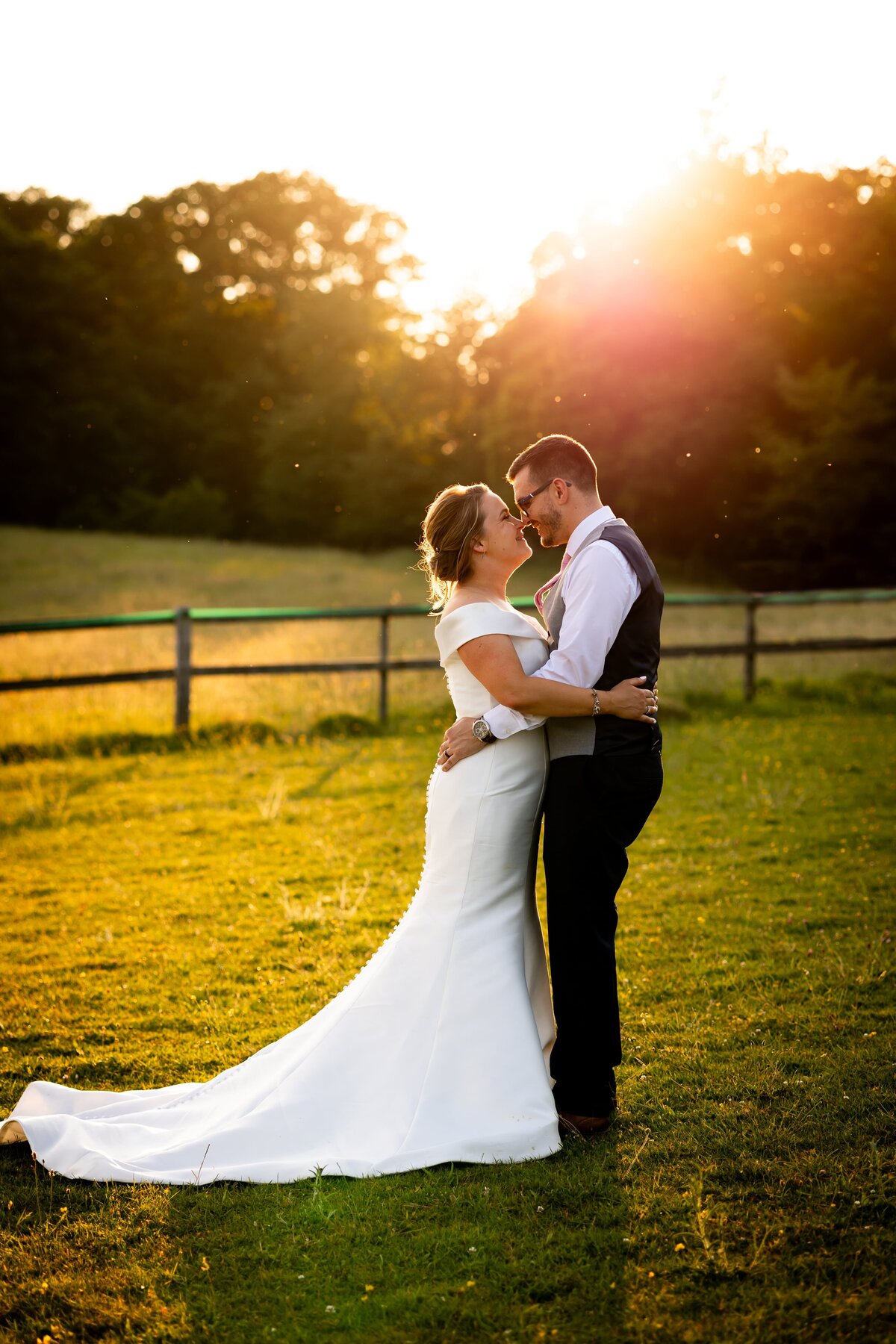 bride and groom in loving embrace in the sunset on wedding day