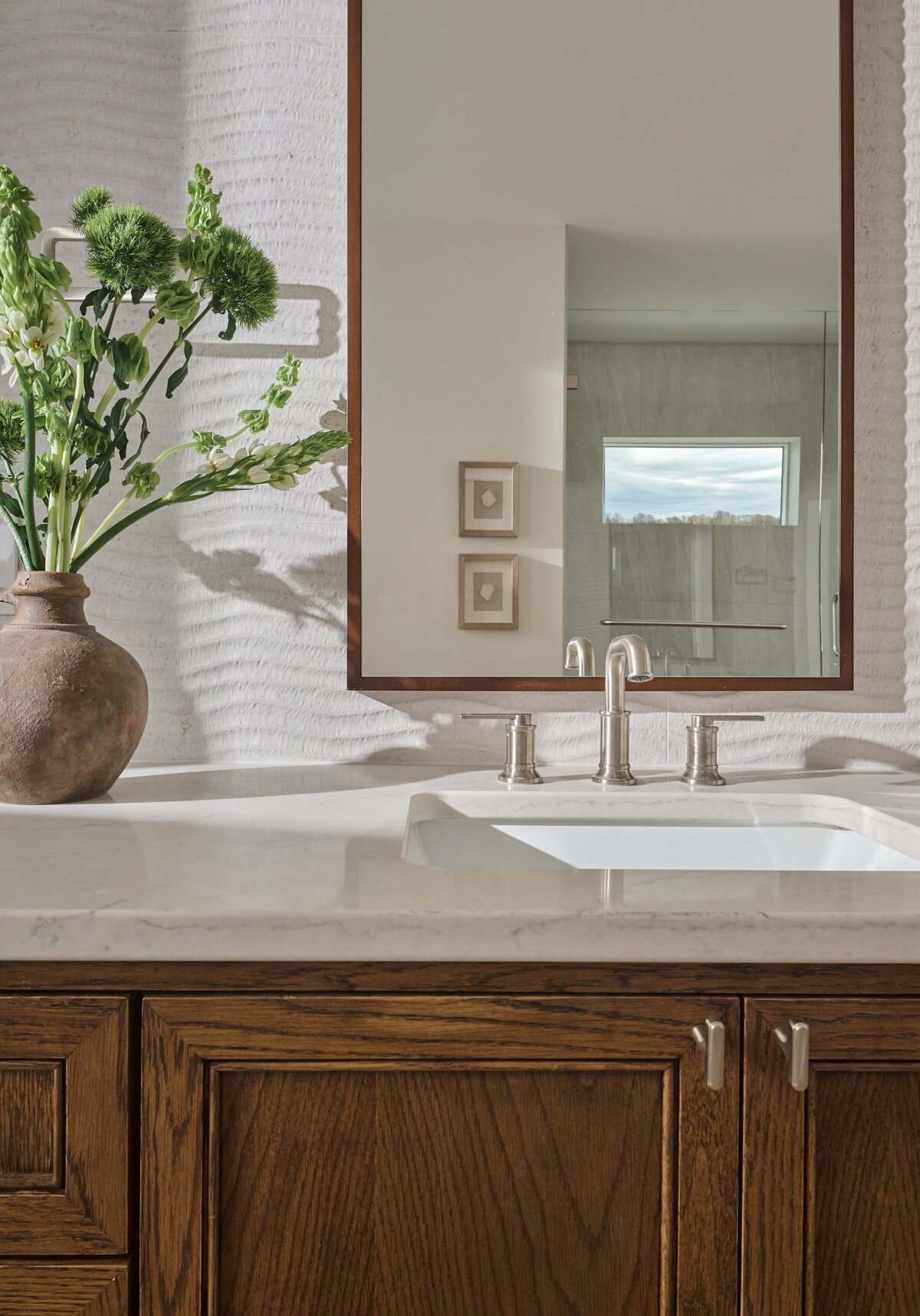 cocoloba homes graham bathroom with wood framed mirror and vase on counter