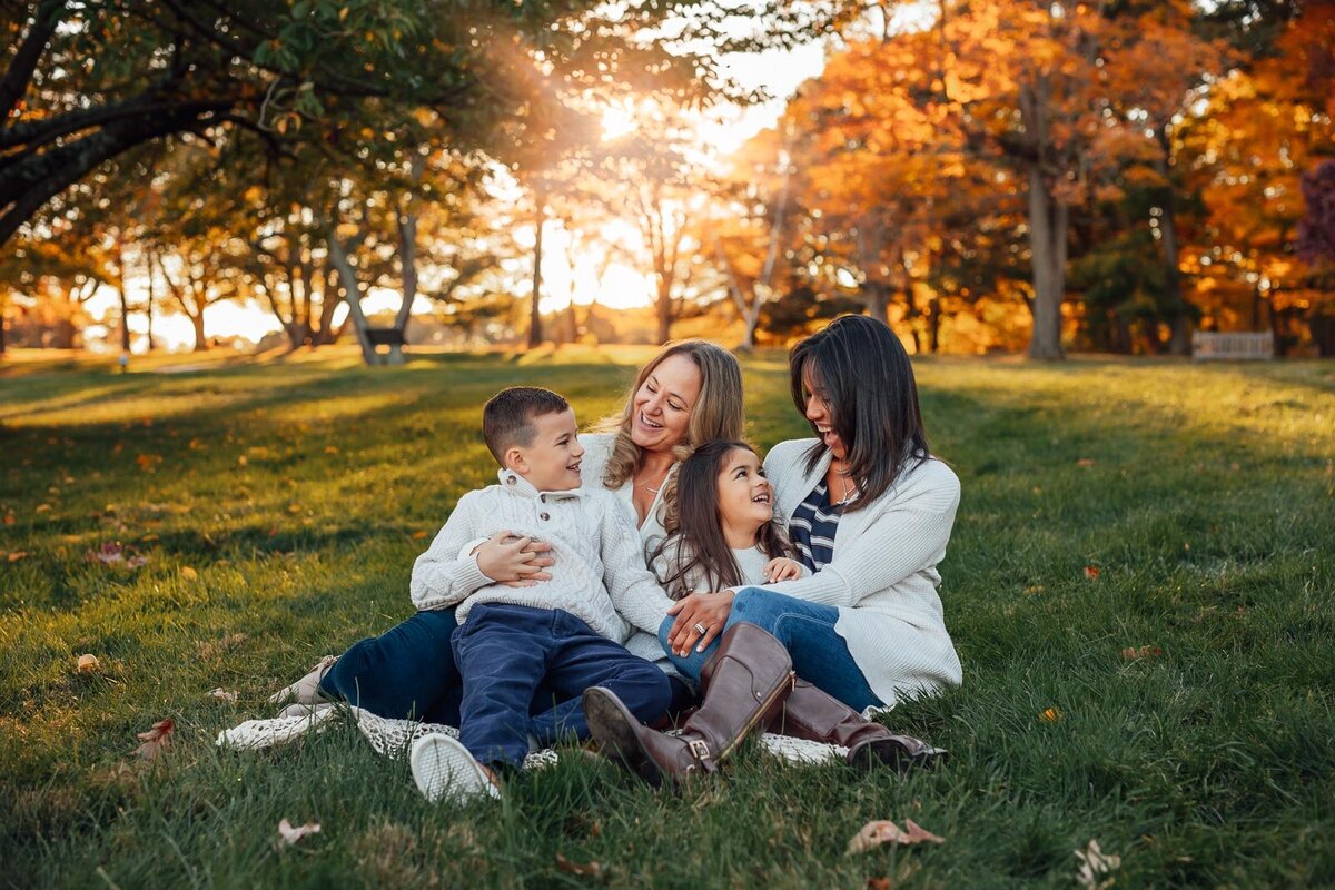 family sitting in grass at sagamore hill family photo session