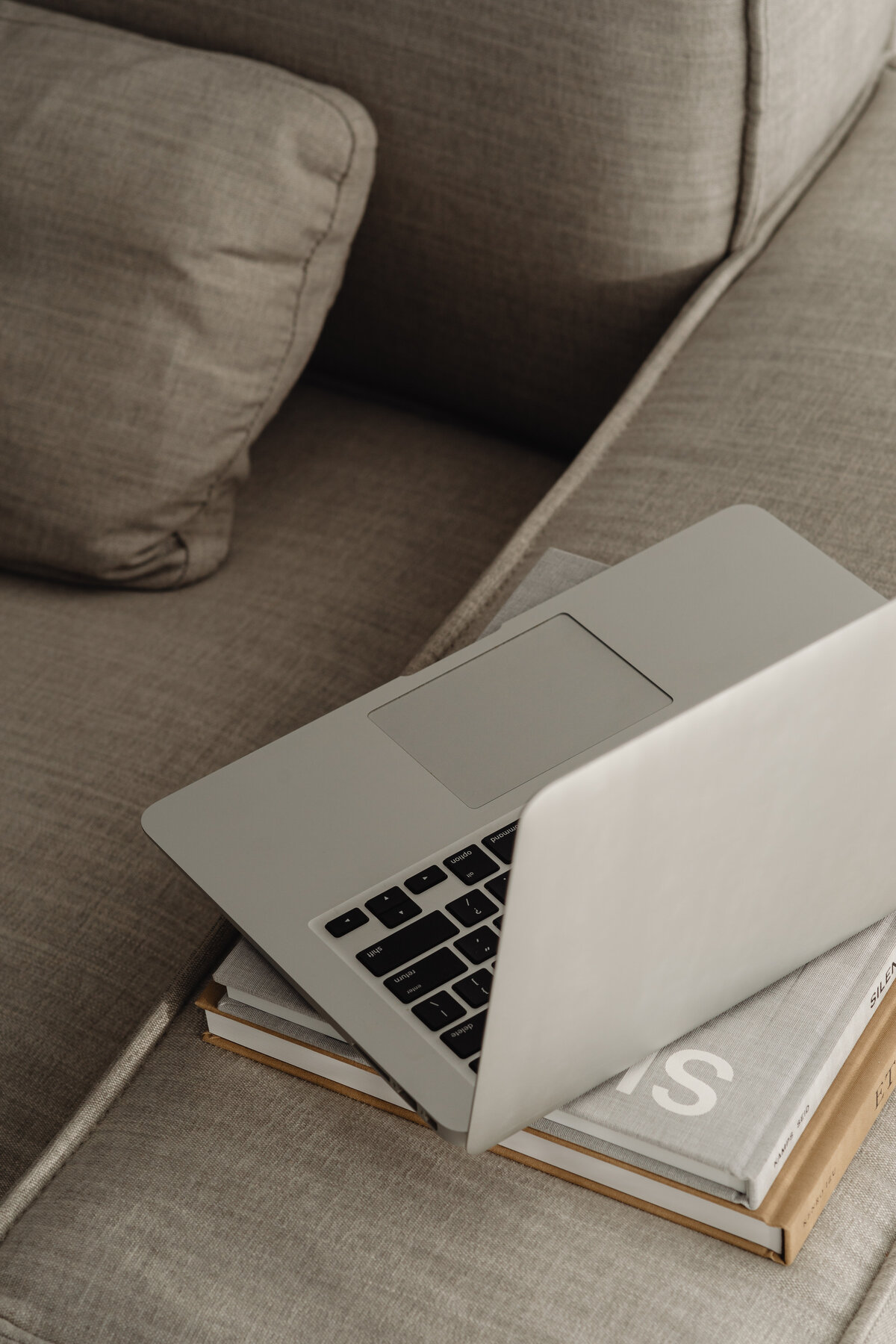 kaboompics_home-office-on-the-sofa-books-laptop-macbook-29695