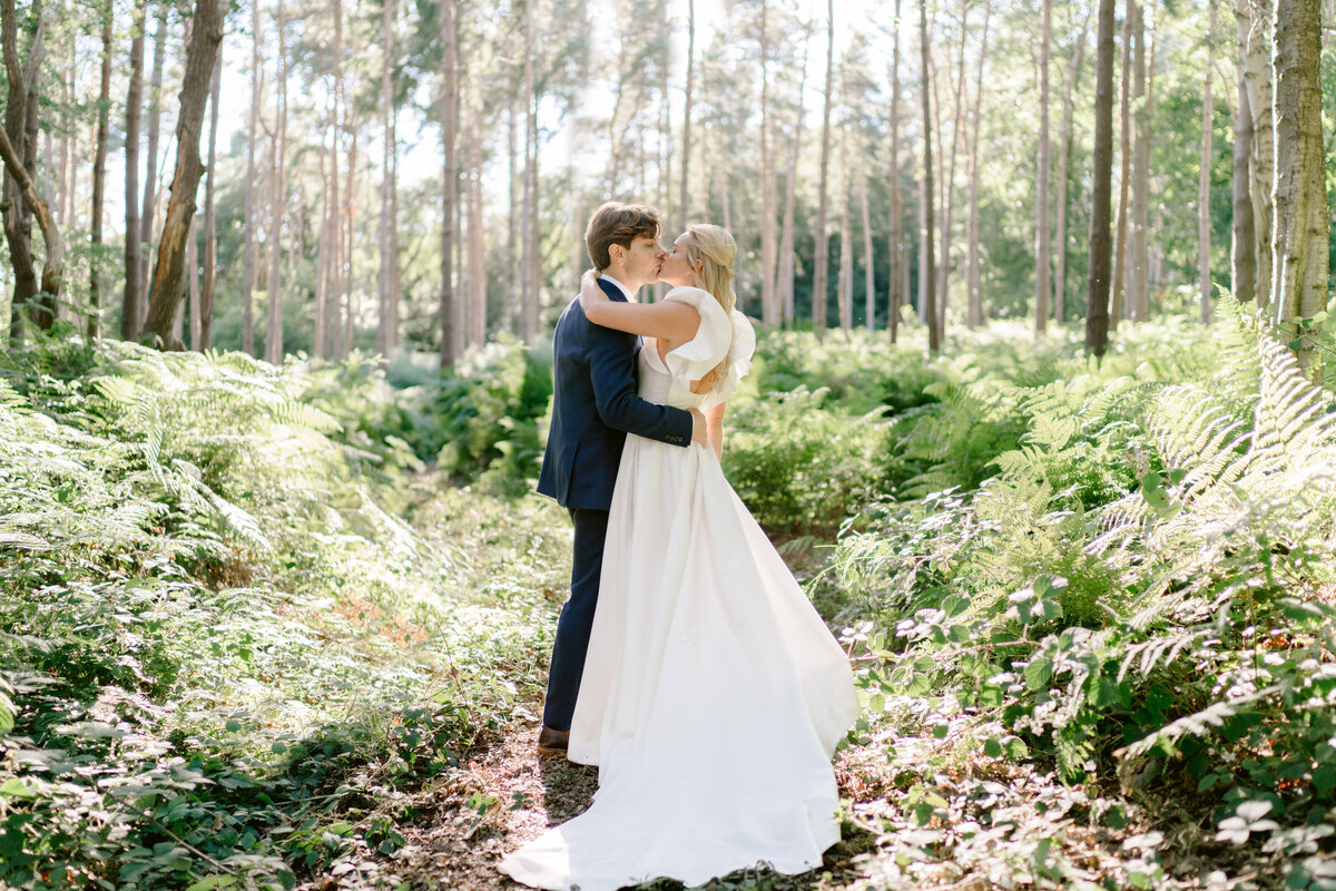 bride and groom kissing in the woods at at peckforton castle