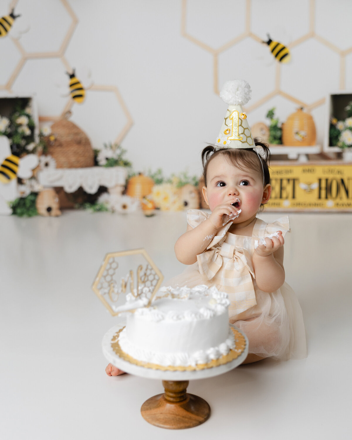 Adorable little one celebrating her first birthday in the sweetest way bee-themed cake, golden giggles, and lots of love. Captured by Yucaipa cake smash photographer Kaitlyn Dawn Photography.