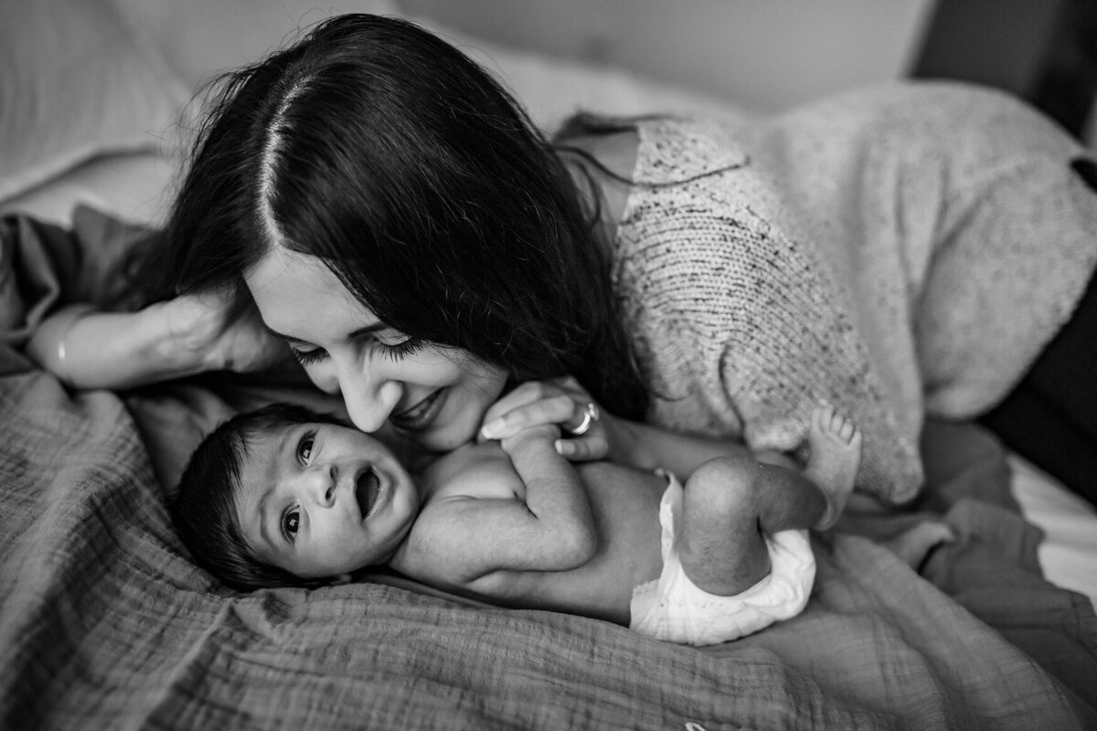 in home newborn photo of mom kissing baby in black and white