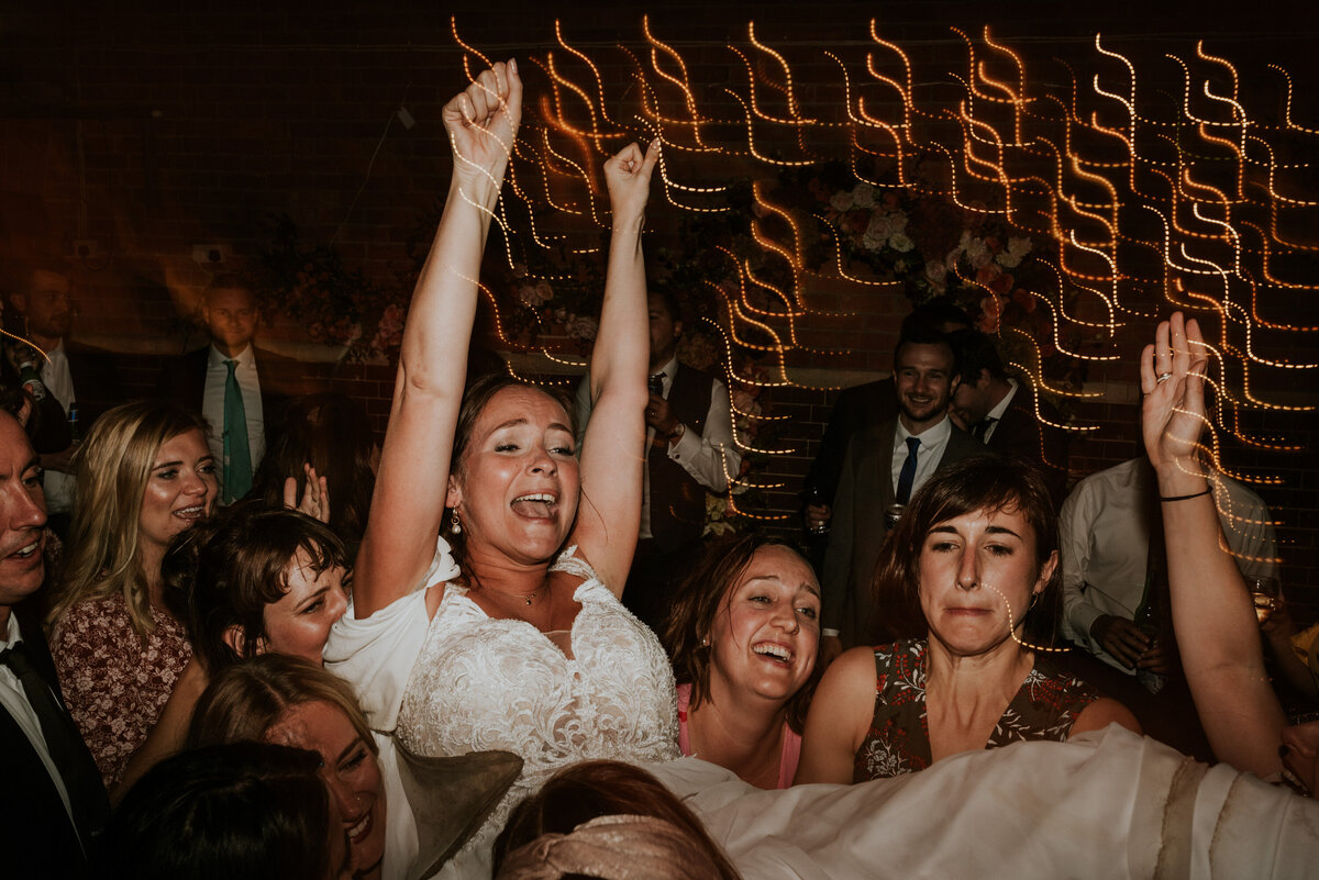 Bride crowd surfing on dance floor