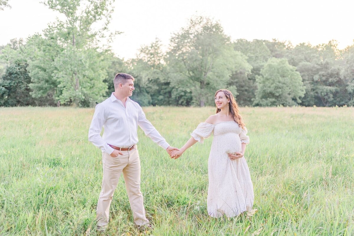 expecting couple holding hands during Centreville, VA maternity photos