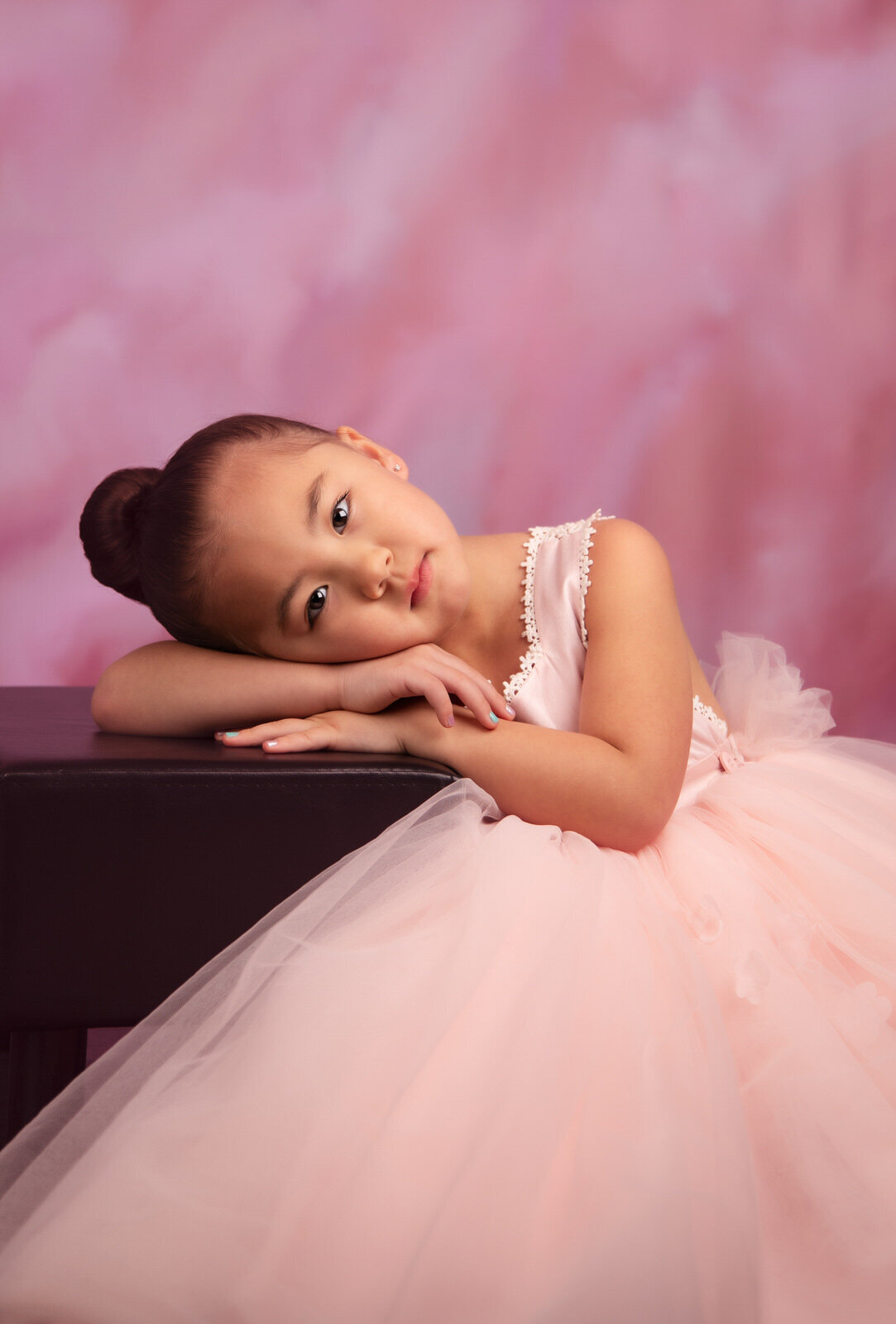 girl-in-pink-dollcake-gown-leaning-on-stool-in-studio