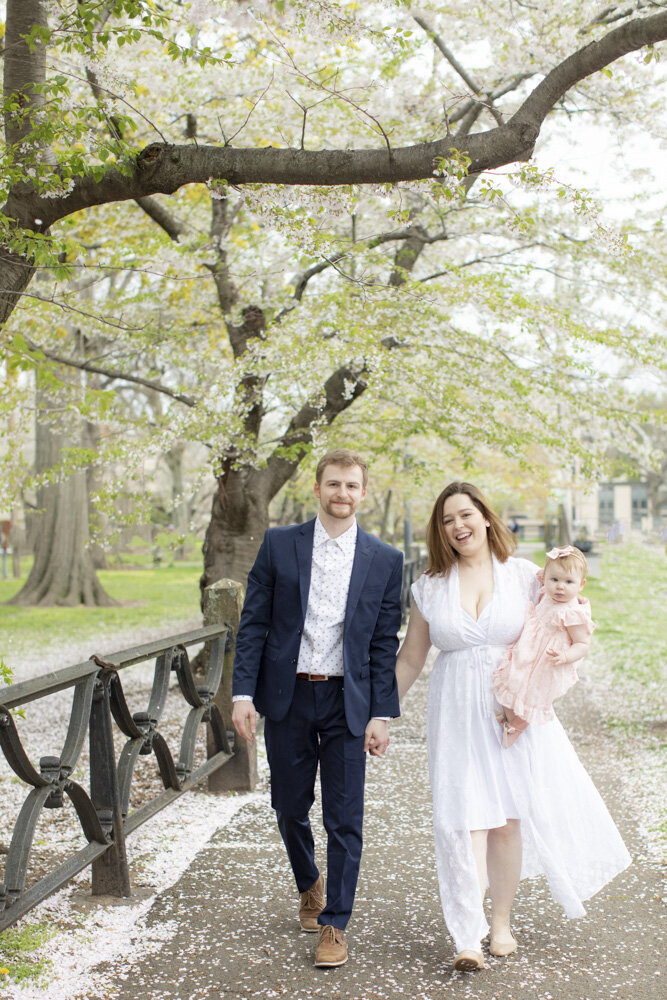 young family of 3 posing in park for spring family portraits