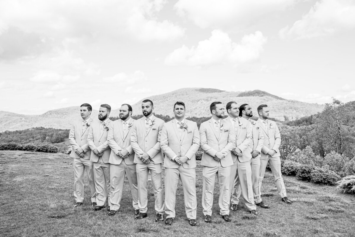 groom and groomsmen posing with mountain background