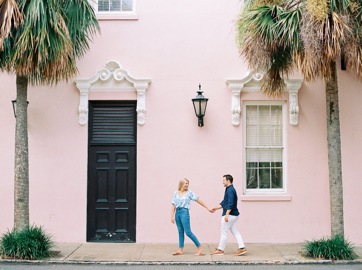 Pink wall and palm trees. Destination engagement session in Charleston. Kailee DiMeglio Photography.