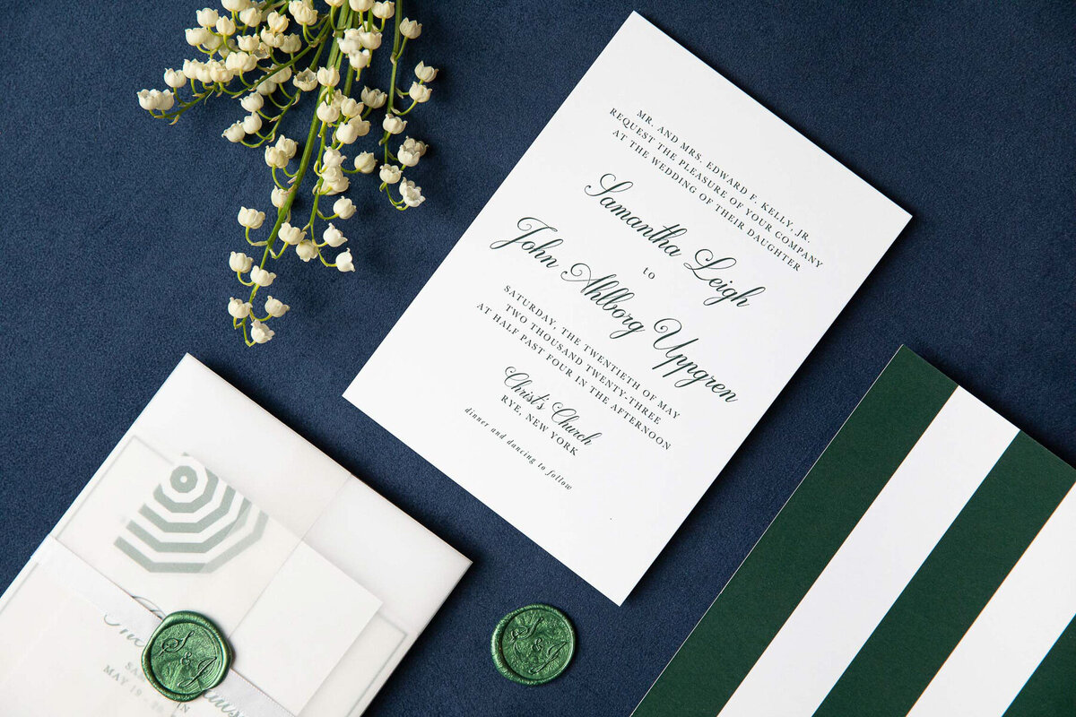 Green and white wedding invitations on a blur background