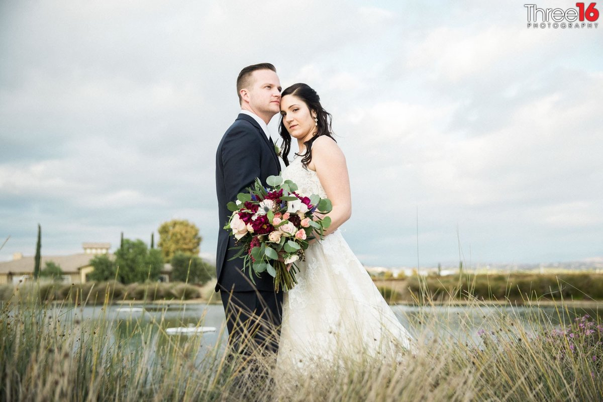 Bride and Groom share intimate moment together in an open field