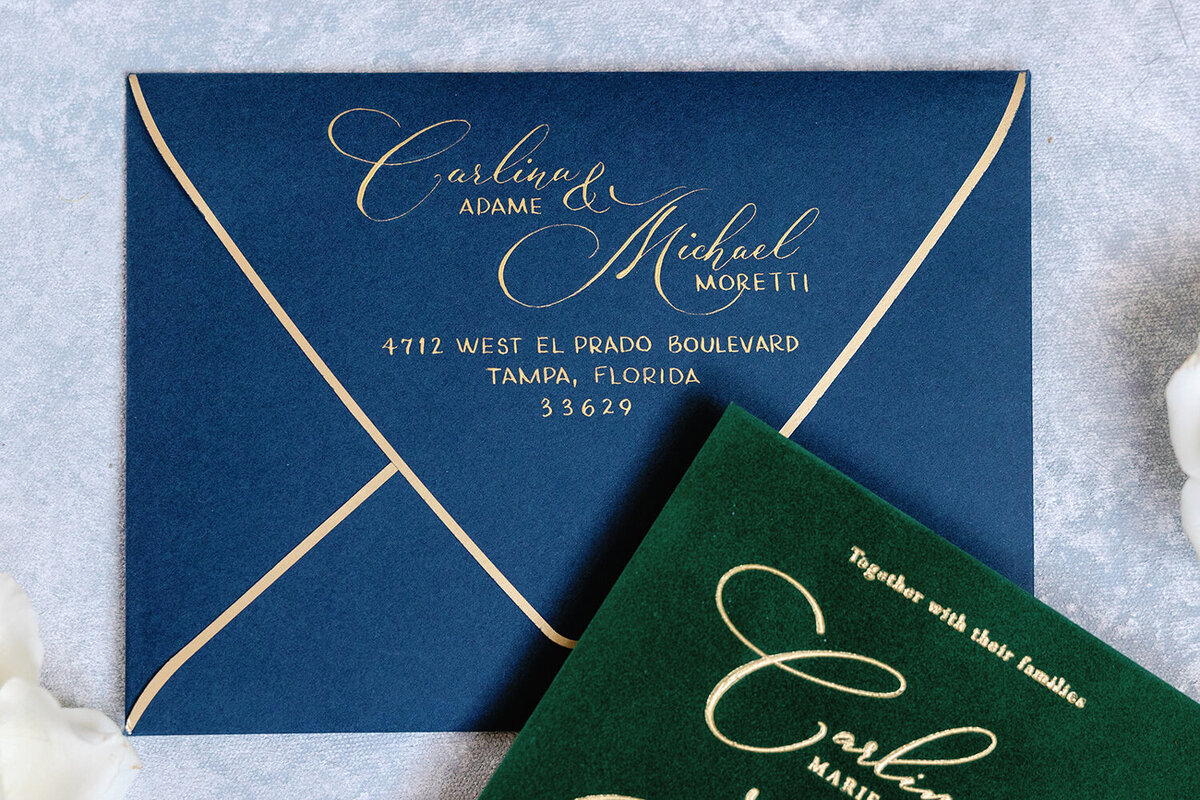 Luxurious gold-edged royal blue wedding envelope with gold calligraphy for a December wedding at the Don Cesar Hotel in St. Pete Beach, FL.