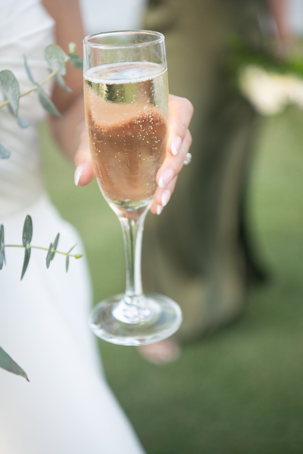 Bride holding champagne glass on Naples golf course