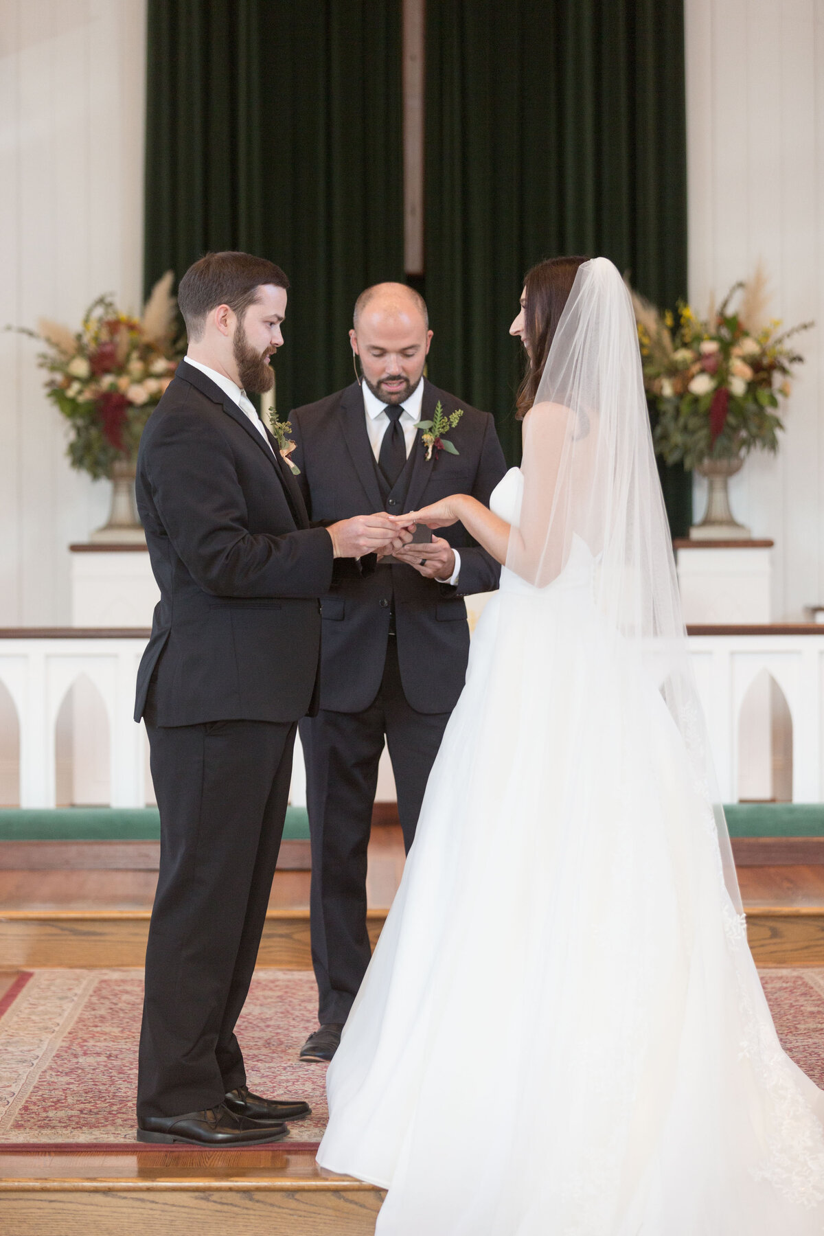 The groom receives his ring from the bride during the wedding ceremony at St. Francis Episcopal Church in Point Clear, Alabama.