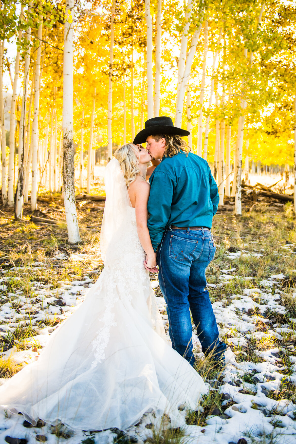 Bride and Groom kissing fall leaves aspens snow Flagstaff cowboy wedding