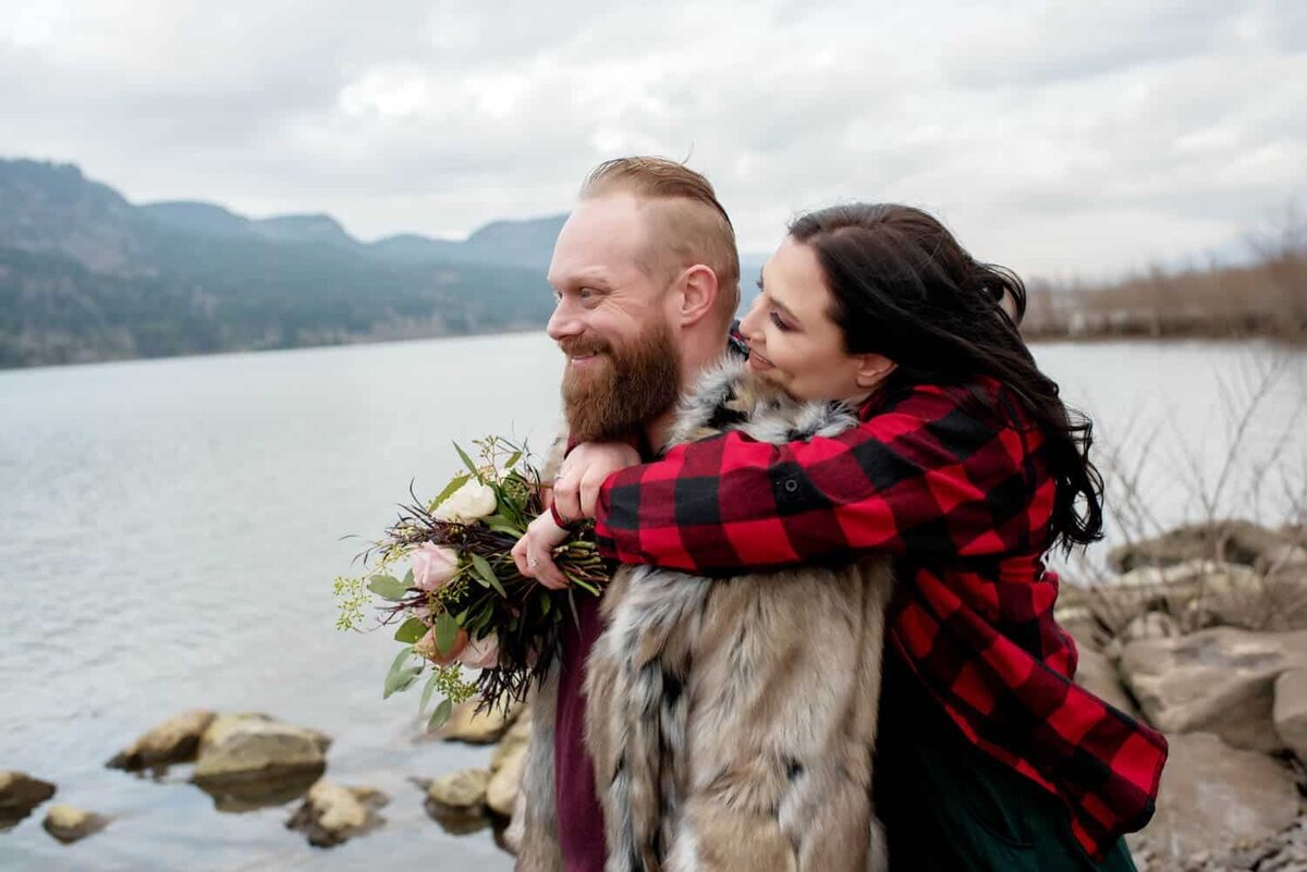 a woman hugs behind her fiance as they overlook the columbia river at dalton point