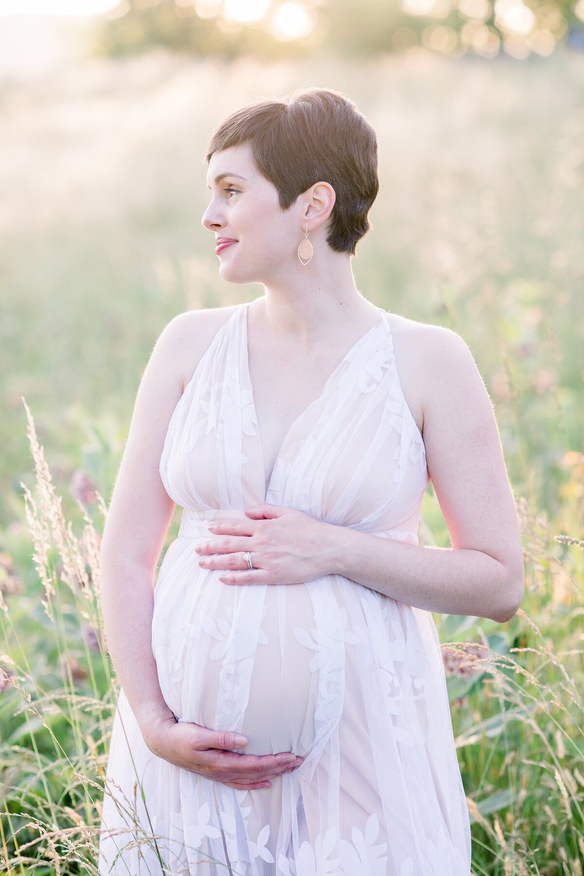 pregnant mom in white tulle dress in a field