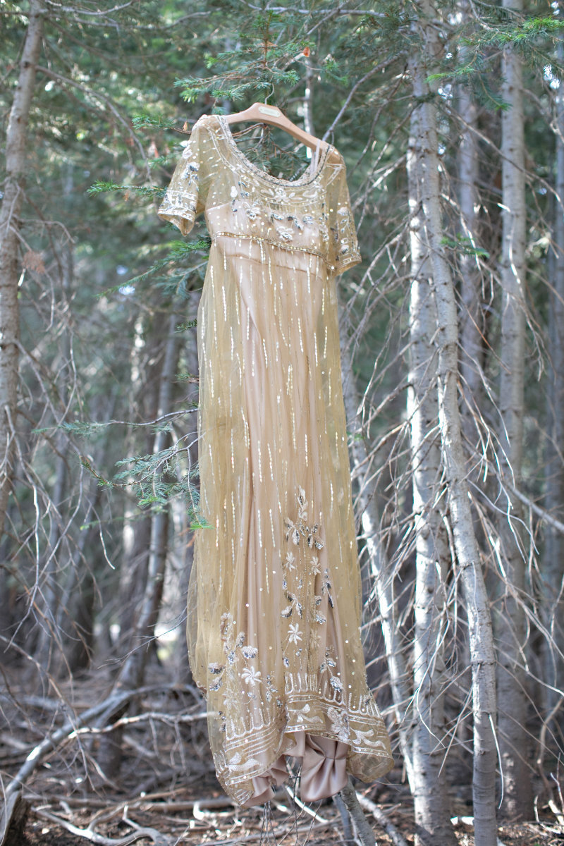 Gold BHLDN Anthropologie dress hung in a pine tree in the Tahoe forest