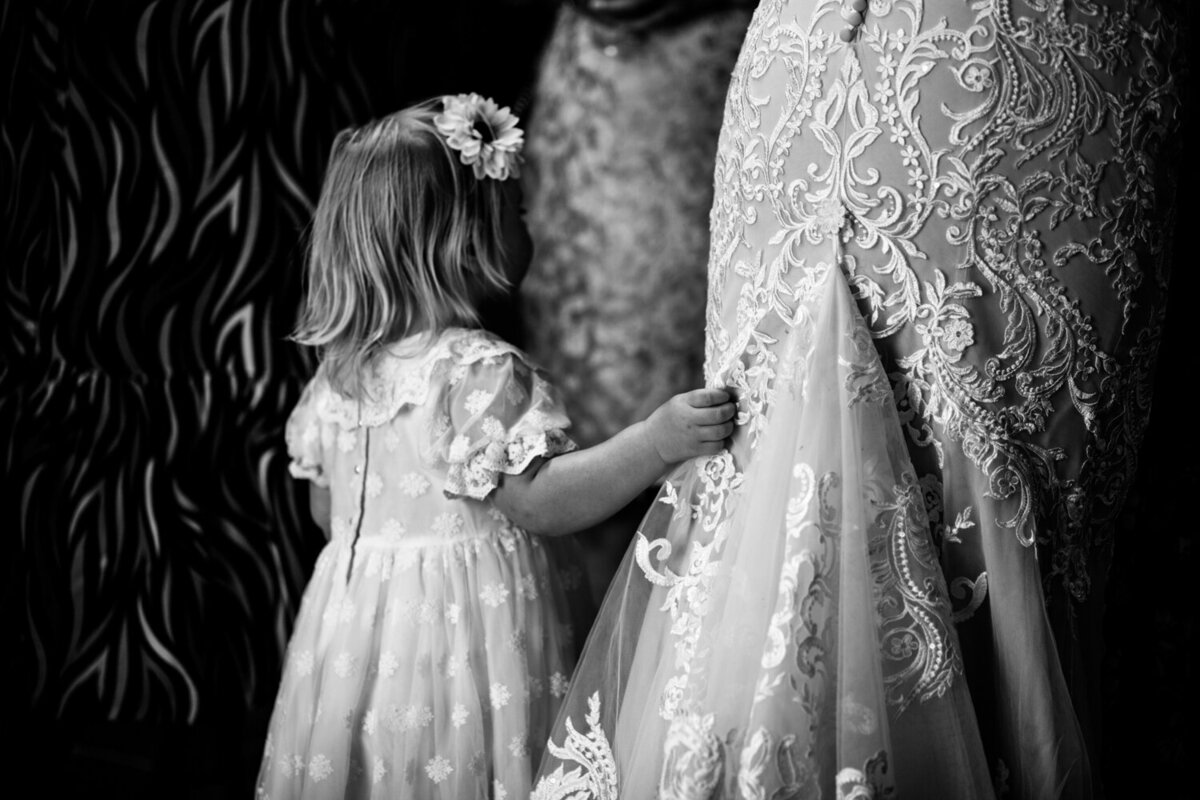 flowergirl holding brides dress