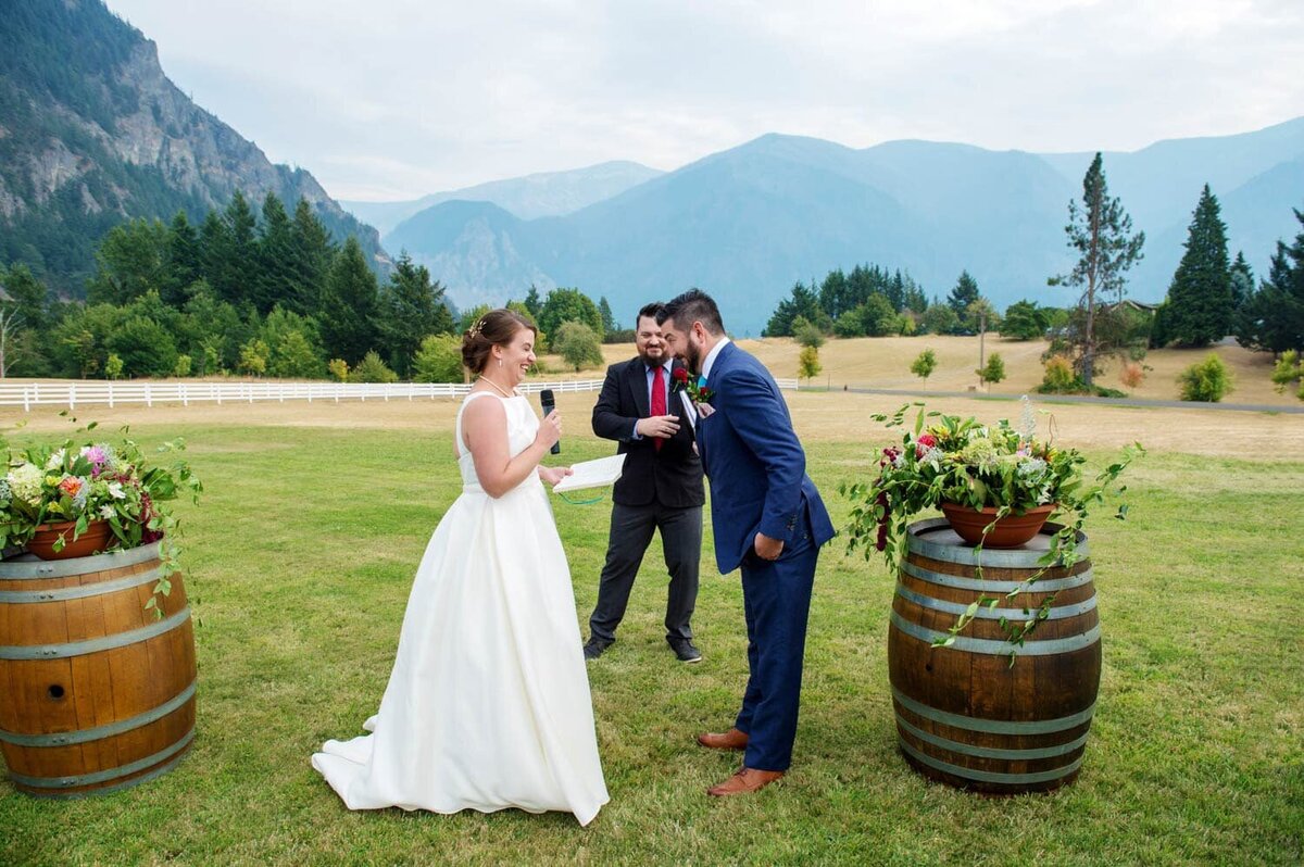 a couple share a silly moment during their wedding vows at wind mountain ranch