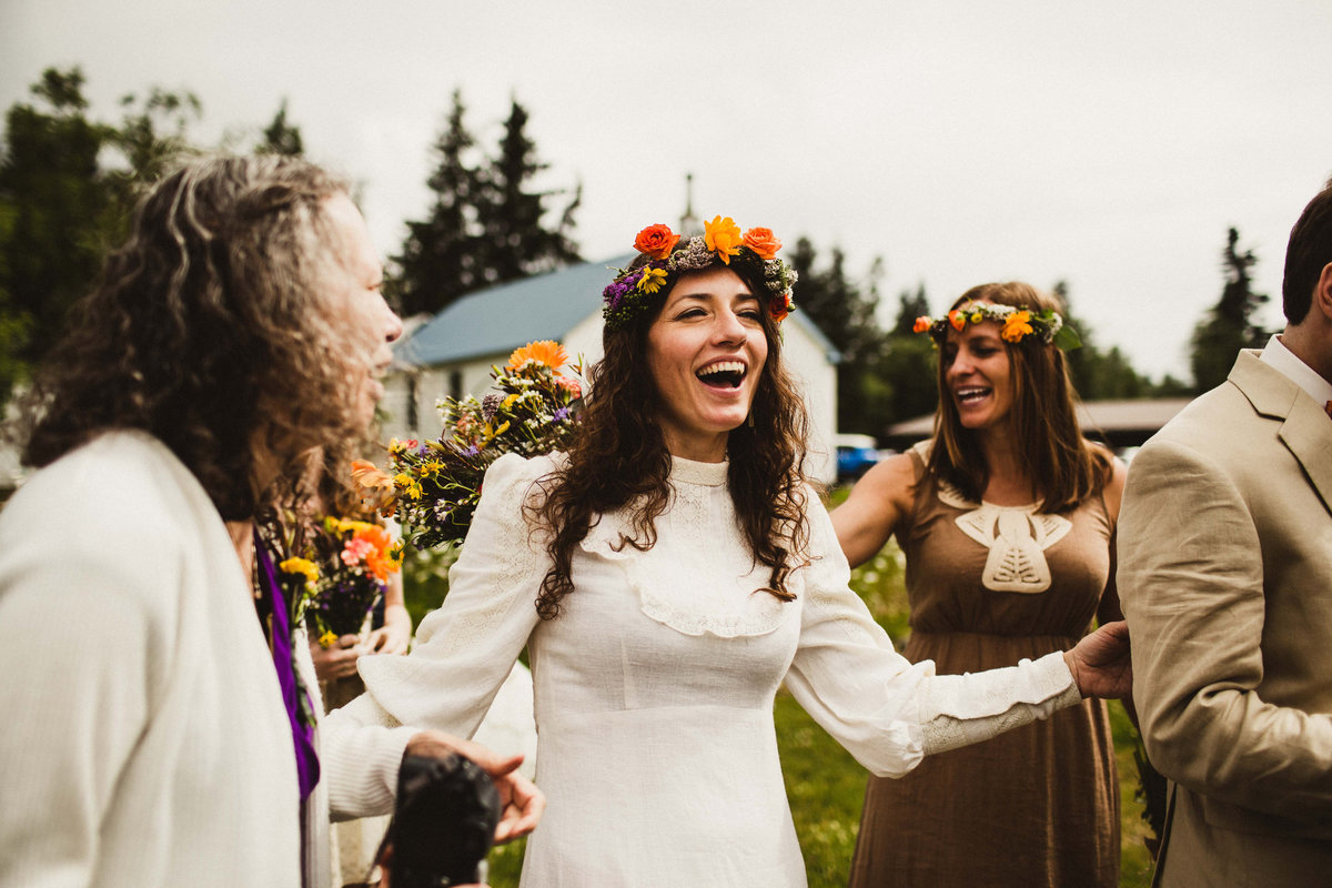 bride with colorful flower crown laughing at moose pass wedding