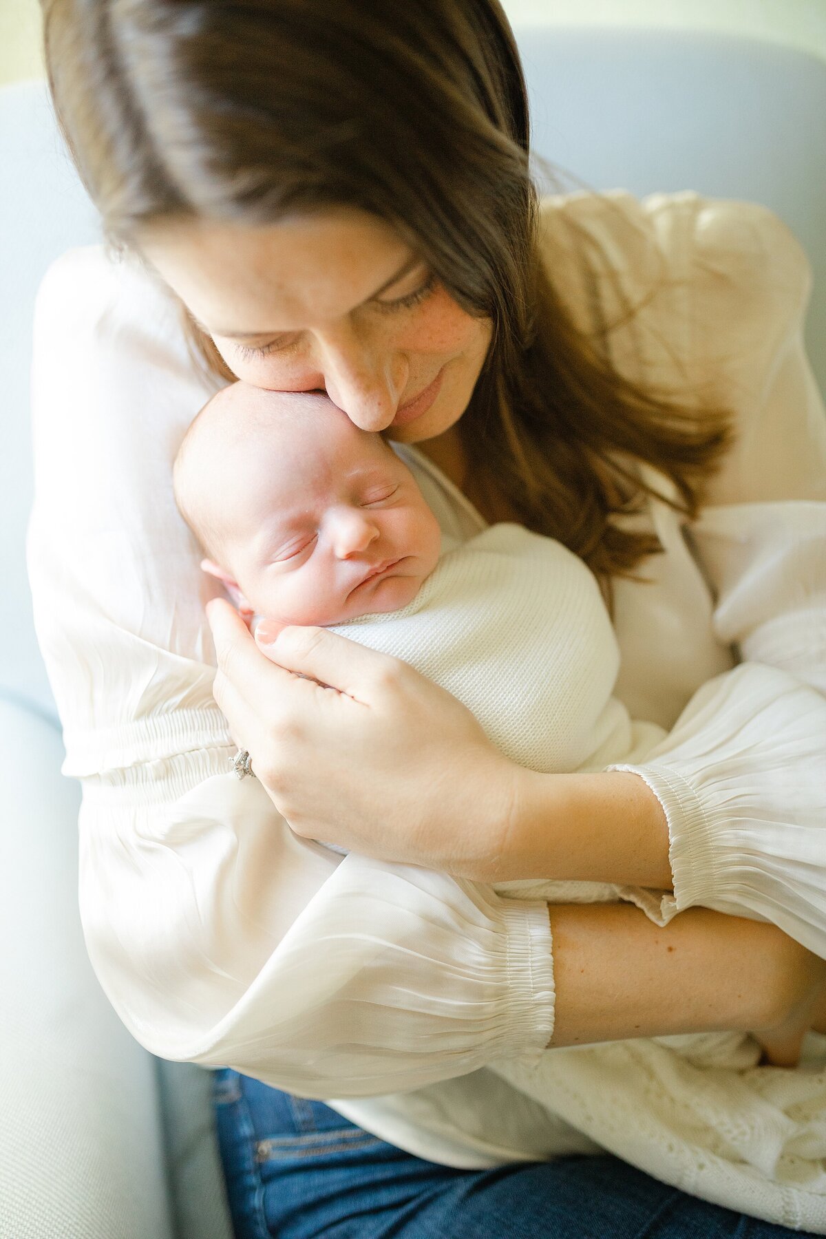 Mother snuggling swaddled newborn son during a newborn photo session in Lexington KY.
