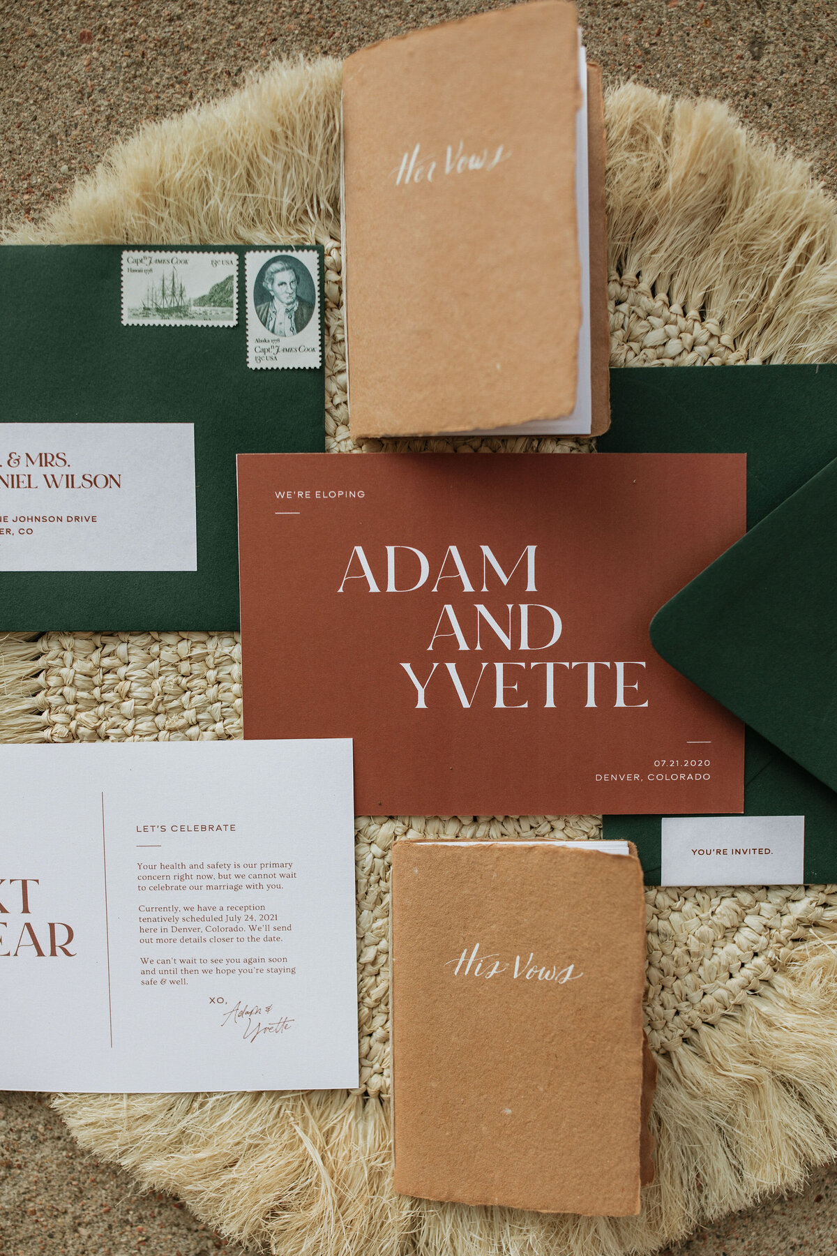mustard textured booklets with white cursive lettering next to dark green envelopes and white card stock save the date with bronze lettering