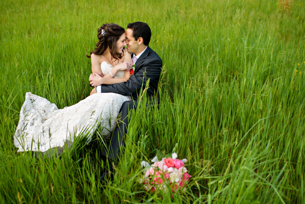 A couple lay in the tall grass after getting married at Holly Hedge Estate in bucks county.