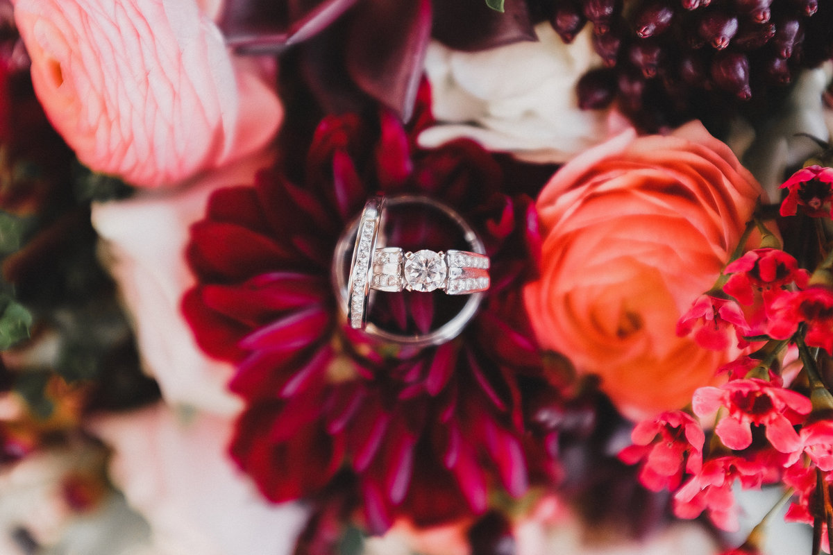 wedding rings with floral arrangement