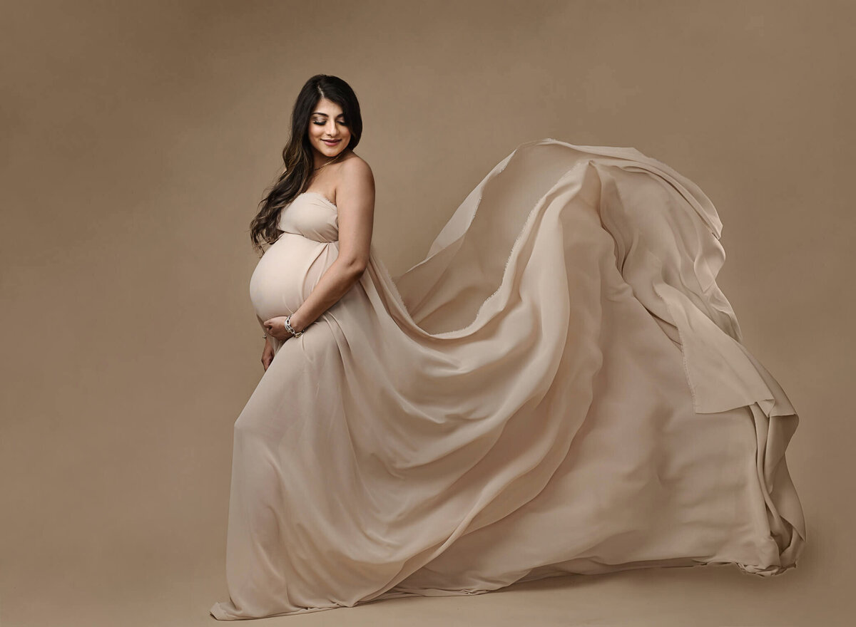 Maternity photo, backlit, studio, wearing fabric