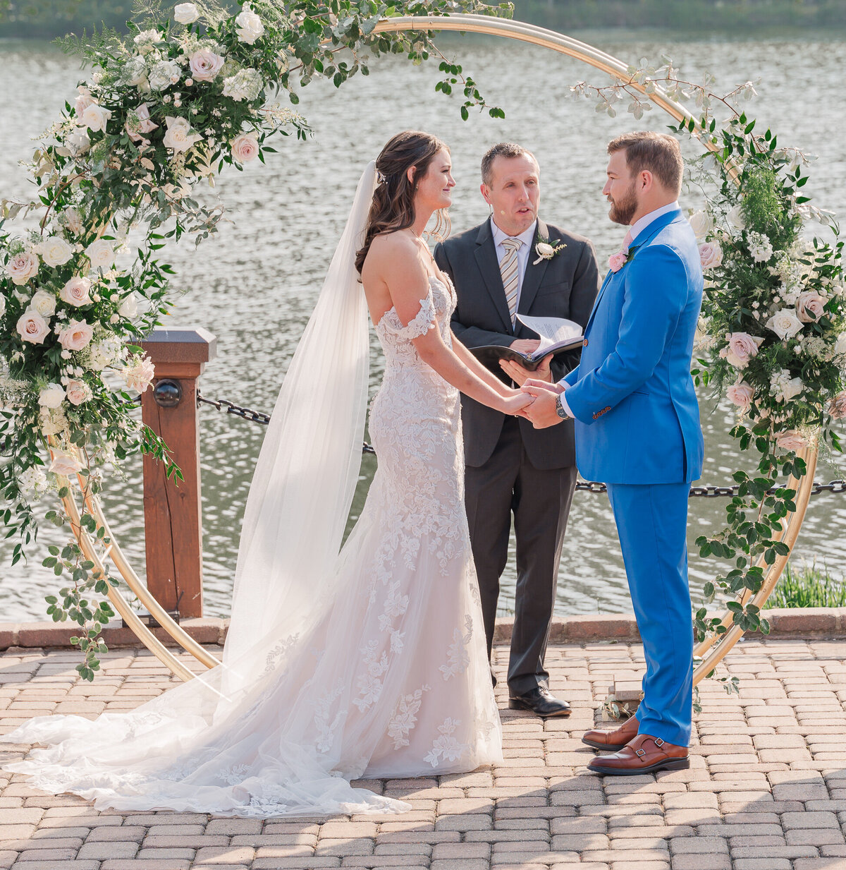 A couple exchanging vows at their waterfront venue in Raleigh enjoying their North Carolina wedding photography by JoLynn Photography