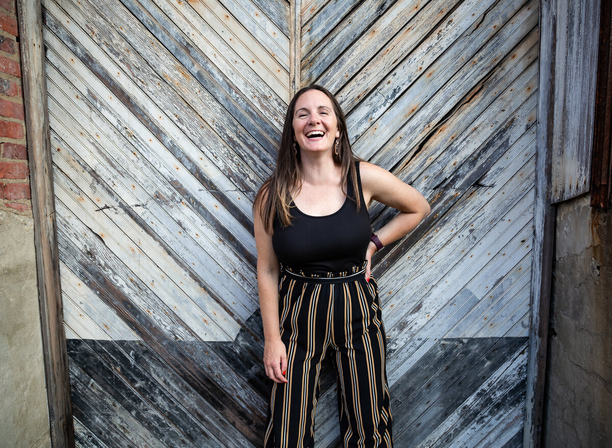 A woman laughs during her branding session in Baltimore, Maryland with Ingrid Berrios Photography