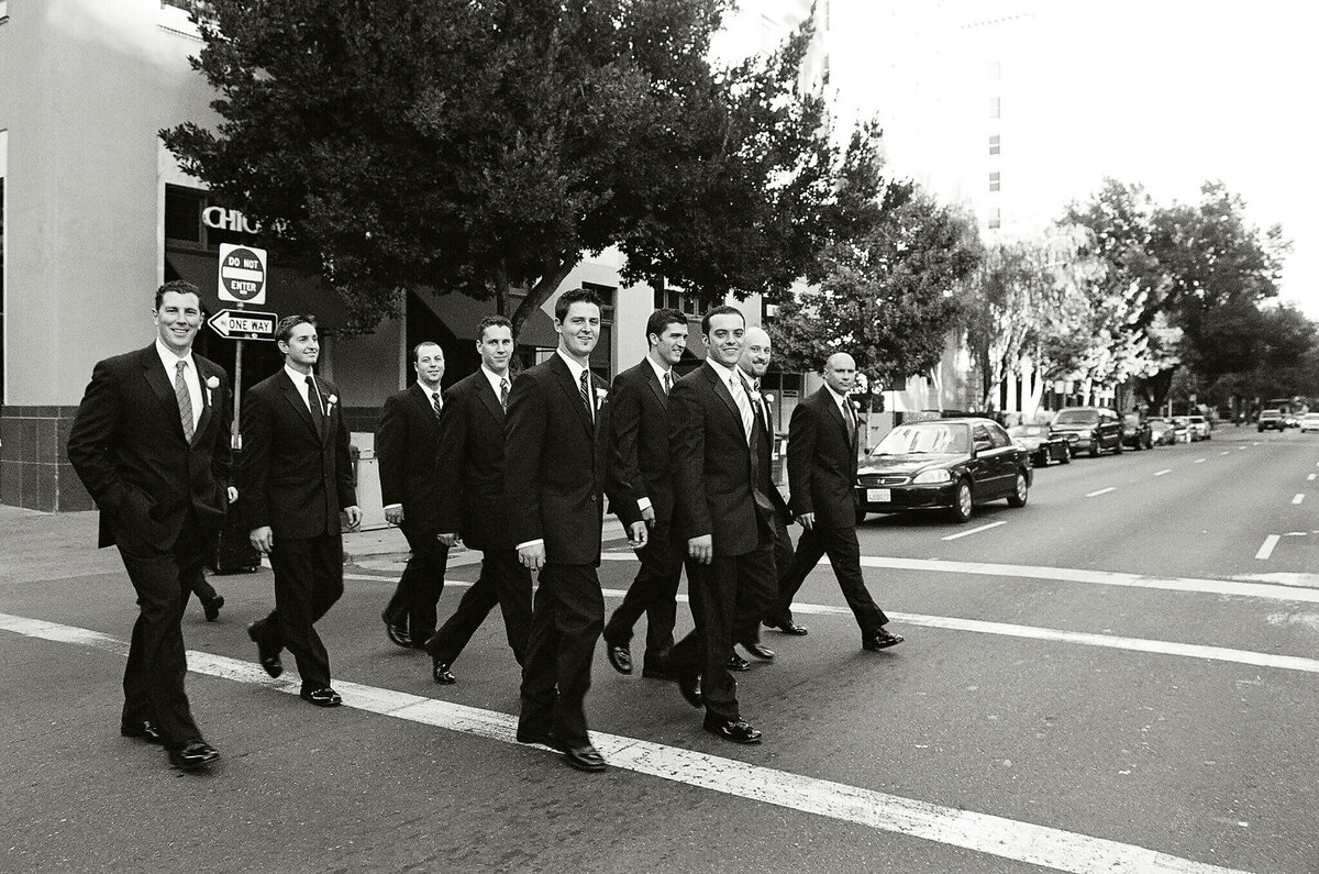groom and groomsmen walking accross the street at Capitol building in  Sacramento