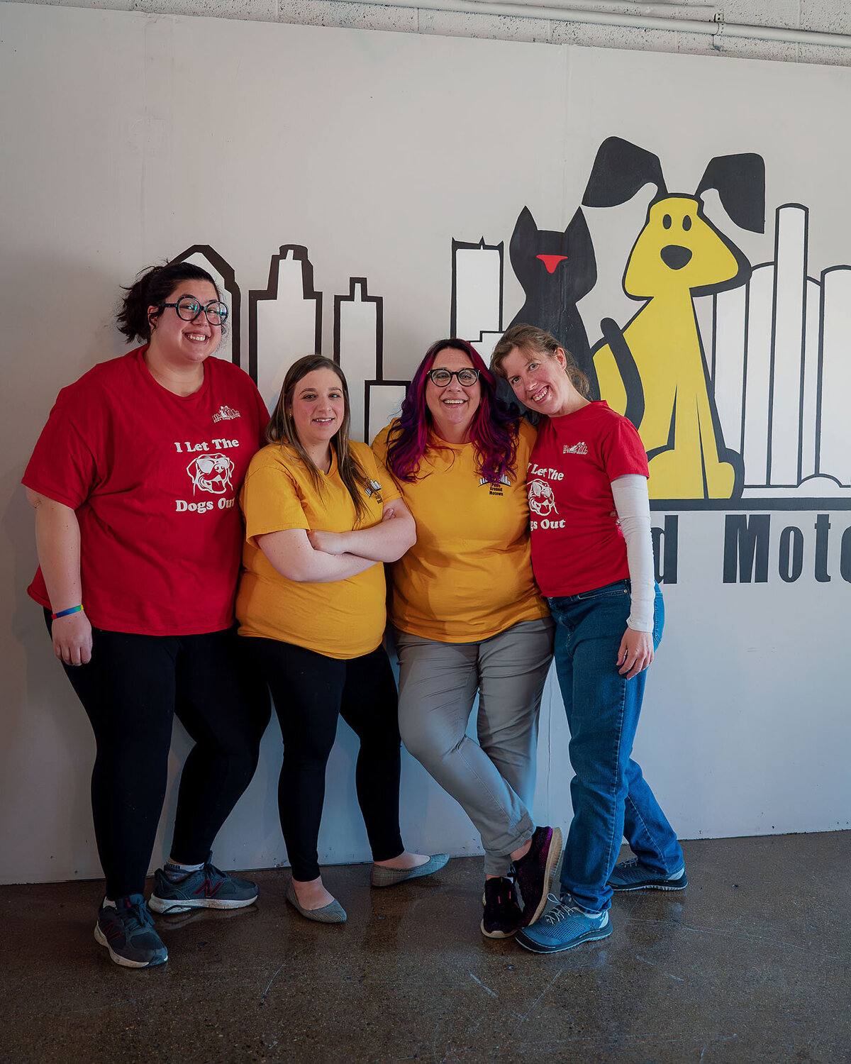 Group of four women staff standing in front of Paws around Motown logo