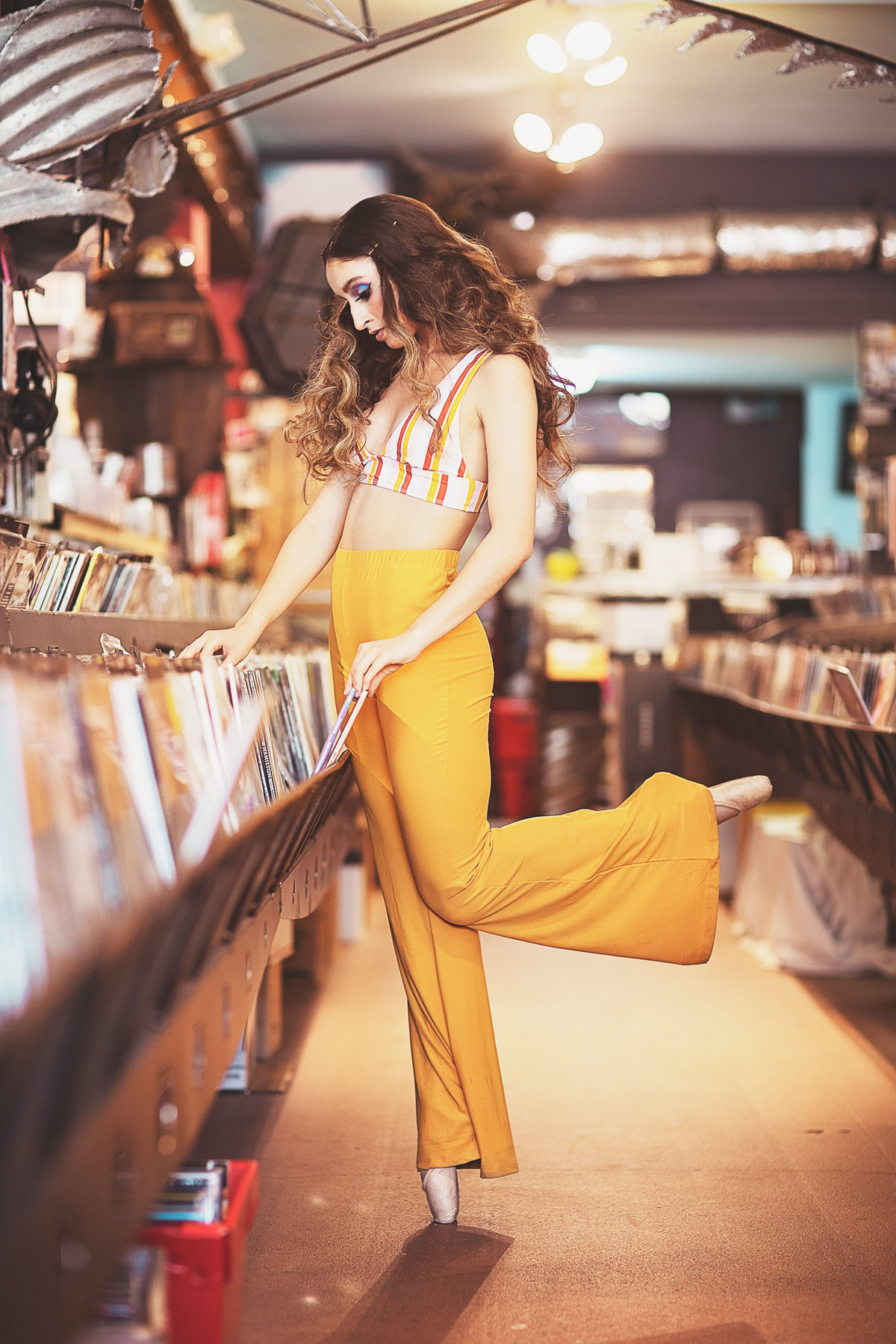 70's themed ballet dancer in pose at record store