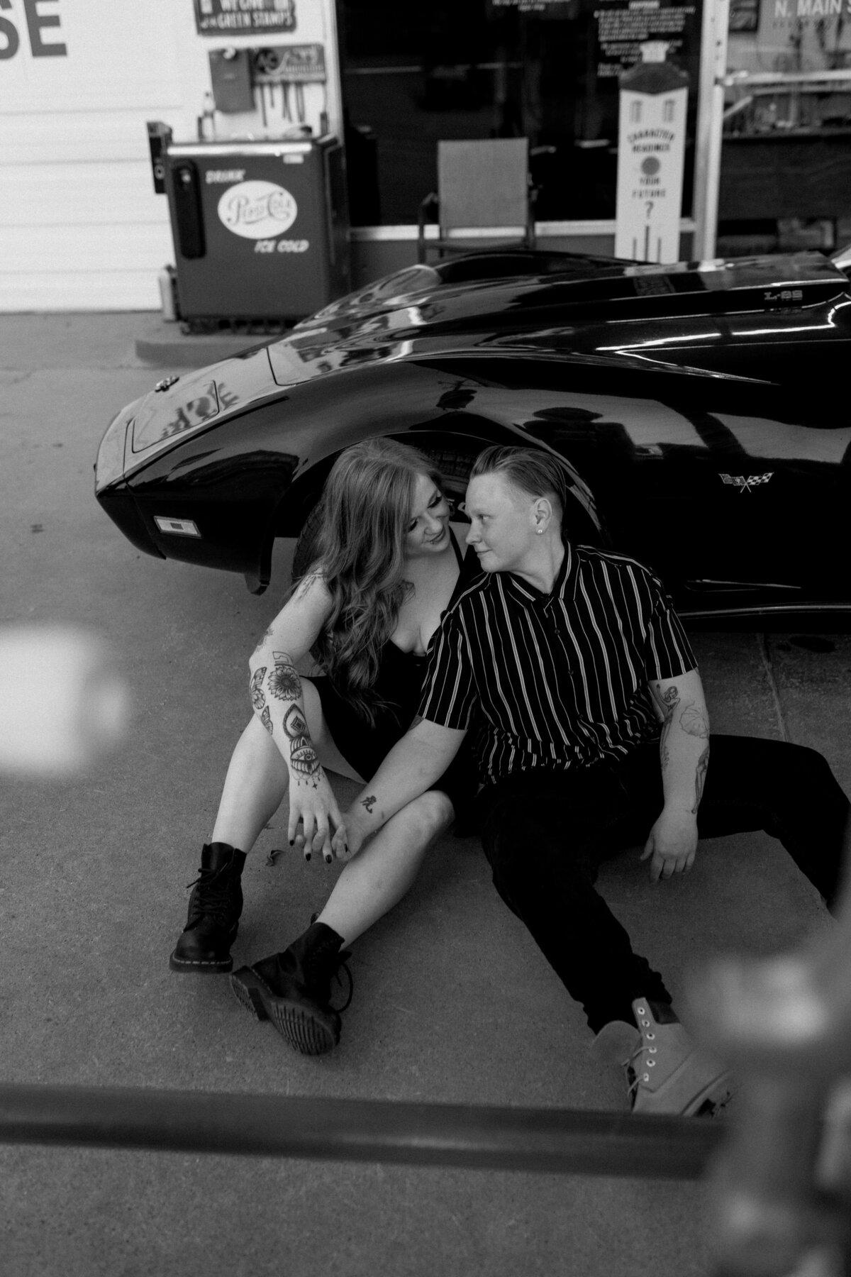 same sex couple posing with vintage car