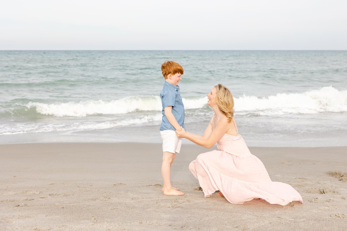 Mom holds Son's hands at the beach