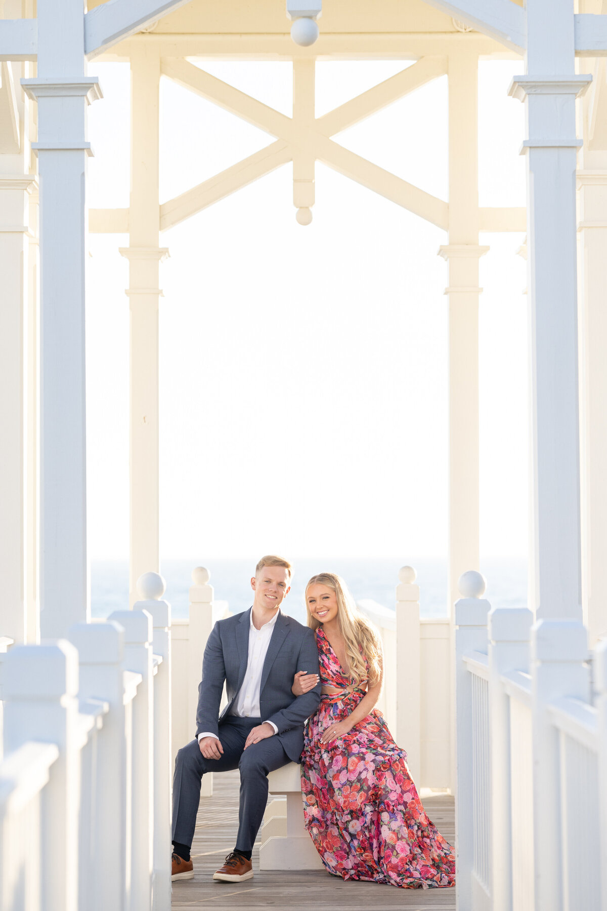 A couple sitting on a small bench together smiling