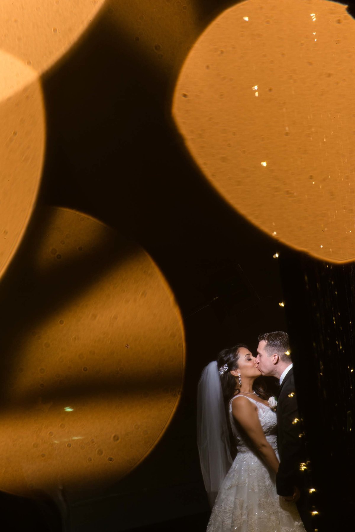 Bokeh photo of bride and groom kissing at Fox Hollow
