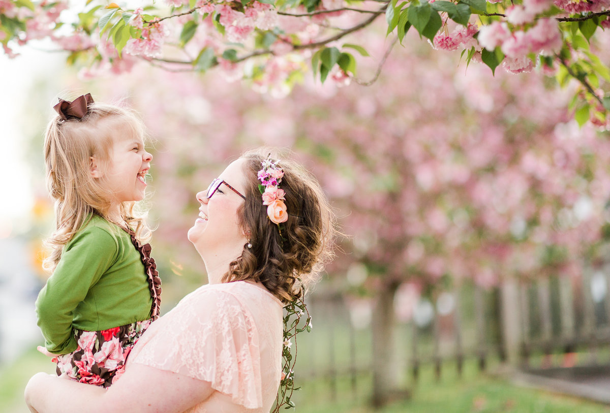 Mother and her young daughter pose with the cherry blossom trees