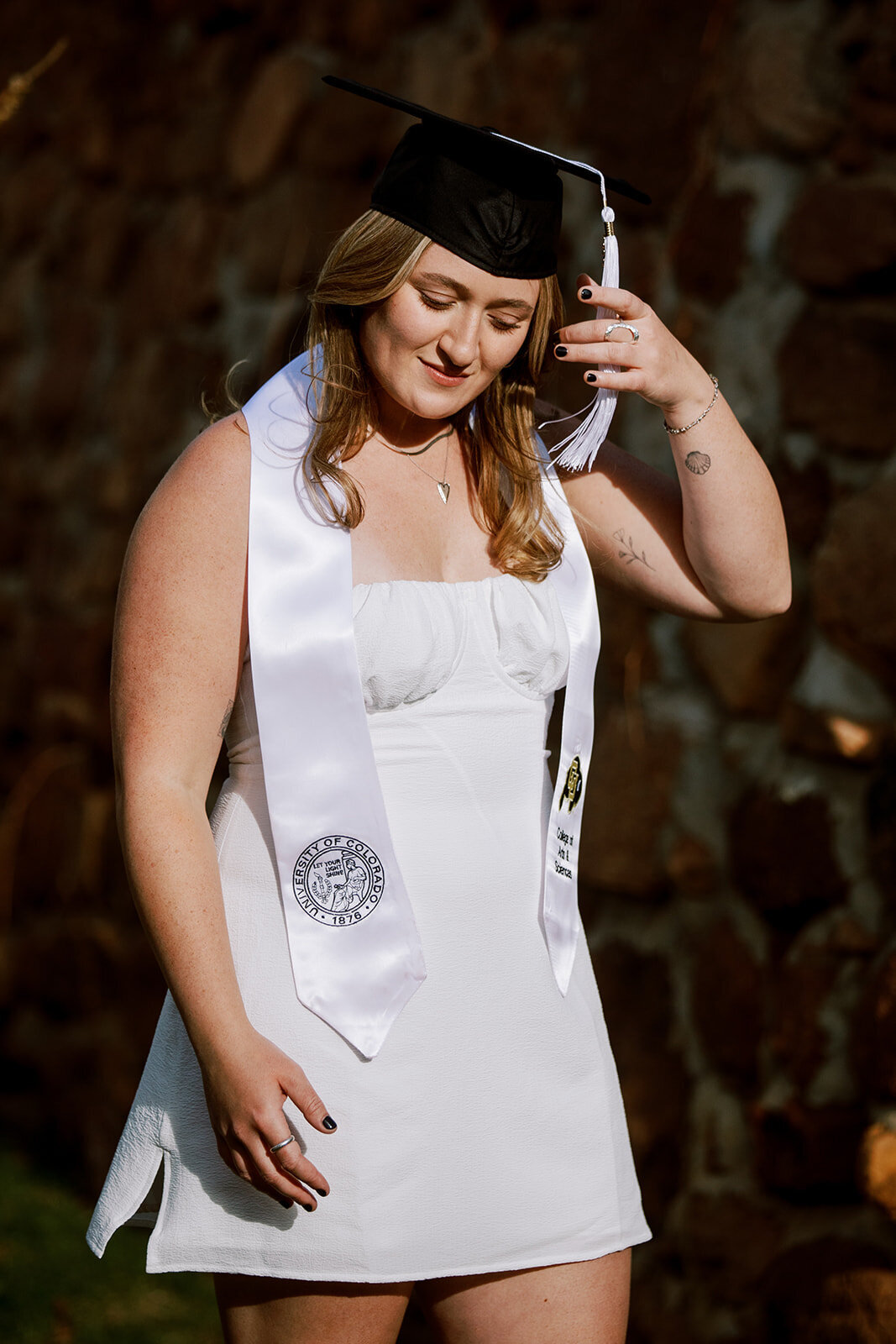 woman feels sash of graduation cap