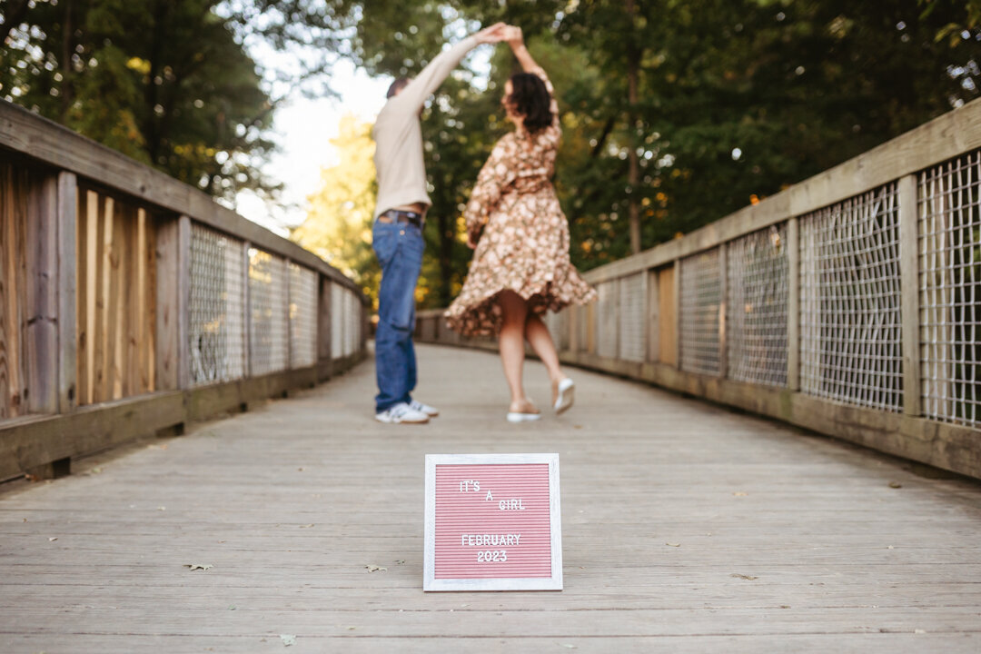 Couple twirling behind a letterboard sign