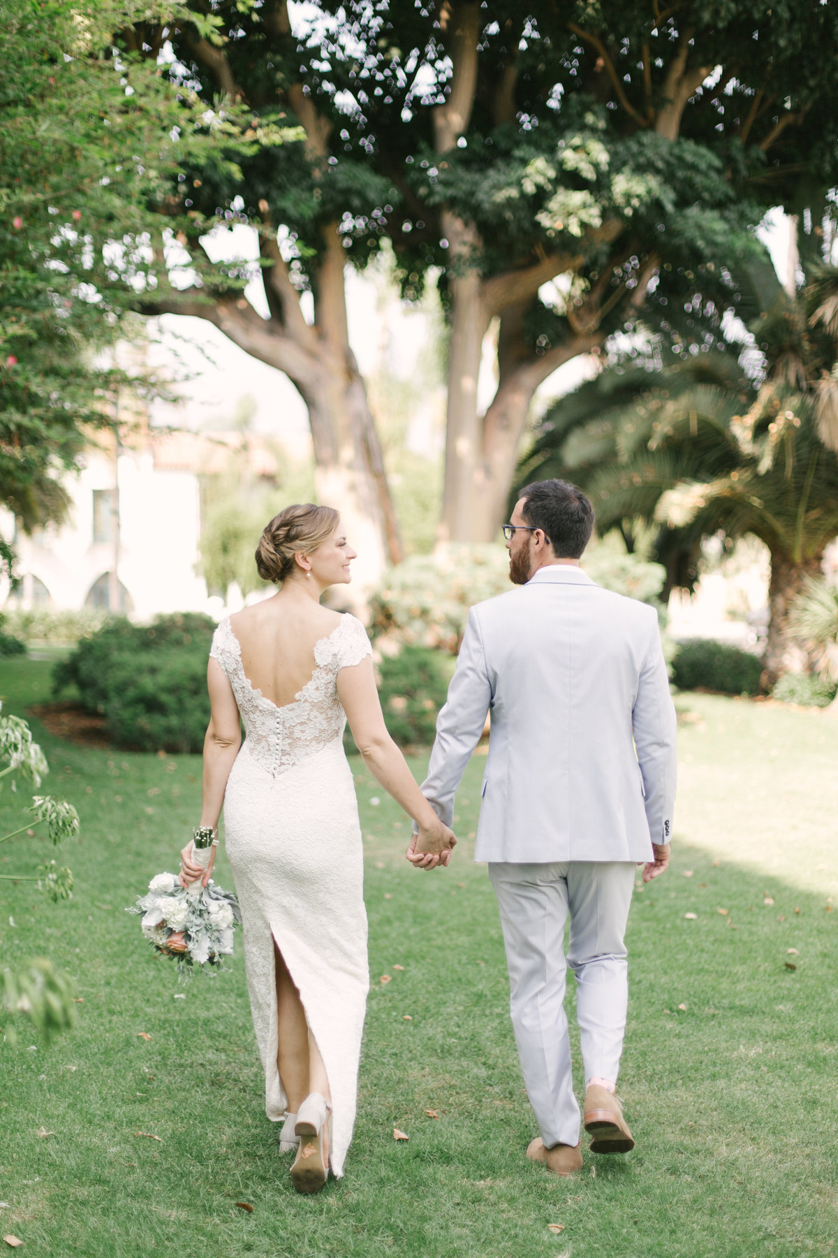 Bride and groom hold hands and walk at Santa Barbara Courthouse wedding