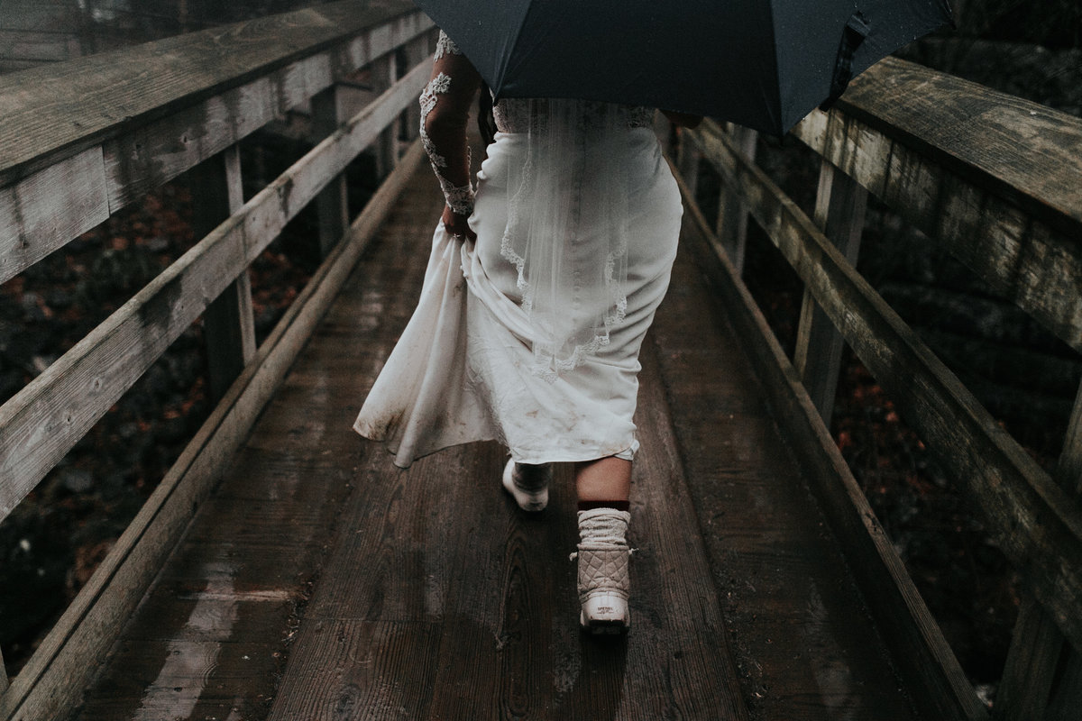 Bride walking in the rain near Moore Cove Falls
