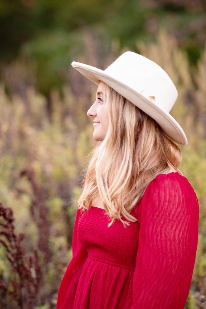 Senior session of young woman in a red dress and hat