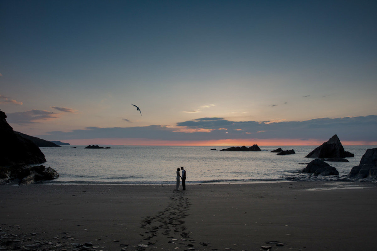 Beautiful sunset wedding photo of Bride and Groom on Beach at Tunnels Beaches