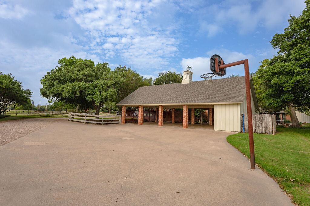 Large parking area and basketball hoop at this 5-bedroom, 4-bathroom vacation rental house for 16+ guests with pool, free wifi, guesthouse and game room just 20 minutes away from downtown Waco, TX.