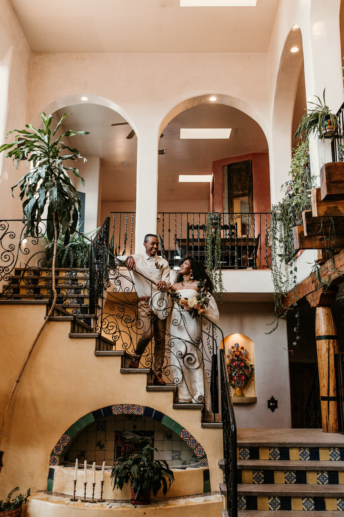 Bride and groom standing on a southwest staircase in Santa Fe venue