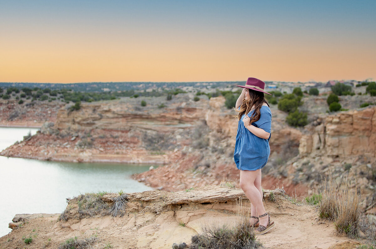 Senior girl standing on canyon wall with Lake Mackenzie in the back